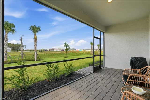 a view of a porch with a table & chairs