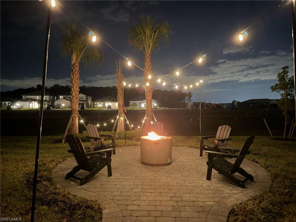 20428 Verawood Loop Estero, FL 33928 - Photo 33 of 50 Patio at twilight featuring a patio area, a fire pit, and a lawn