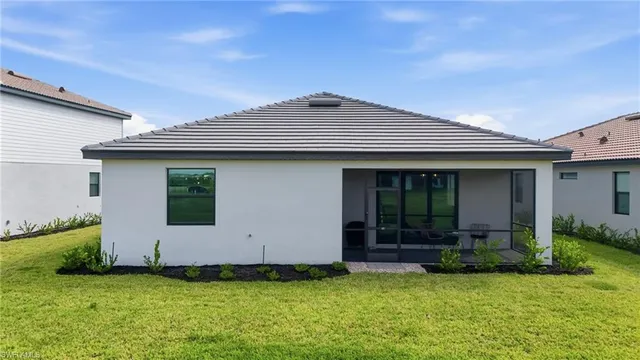 a view of a house with yard and a car park in front of it