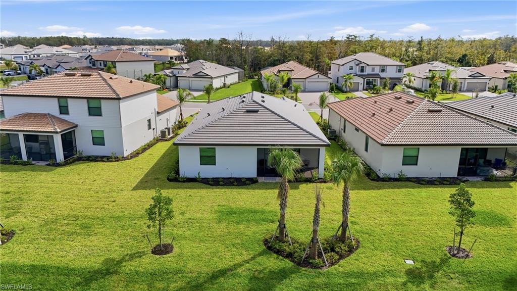 20428 Verawood Loop Estero, FL 33928 - Photo 35 of 50 Rear view of property featuring a residential view, stucco siding, and a lawn
