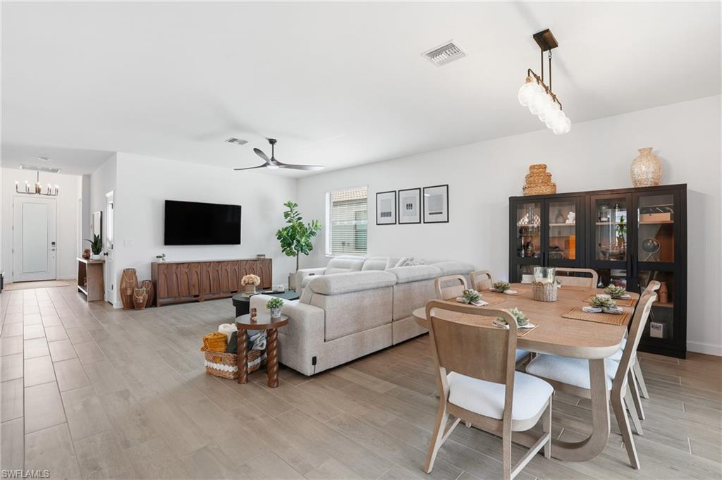 20428 Verawood Loop Estero, FL 33928 - Photo 7 of 50 Dining space featuring wood tiled floors, a ceiling fan, and a chandelier