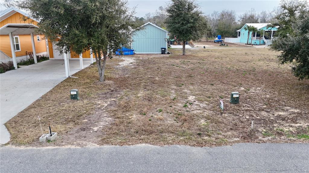 Tbd Southwest Tbd Sw 879th Street Steinhatchee, FL 32359 - Photo 2 of 17 a backyard of a house with table and chairs under an umbrella