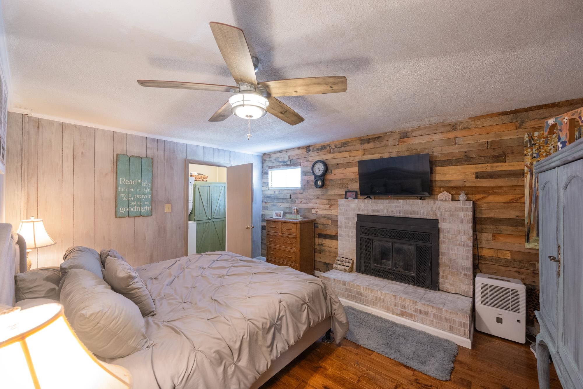 982 Lost Creek Boat Dock Road Decaturville, TN 38329 - Photo 15 of 31 a spacious bedroom with a bed and a fireplace