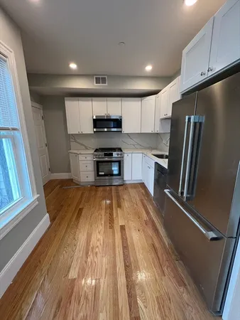 a kitchen with stainless steel appliances a refrigerator a stove top oven and sink