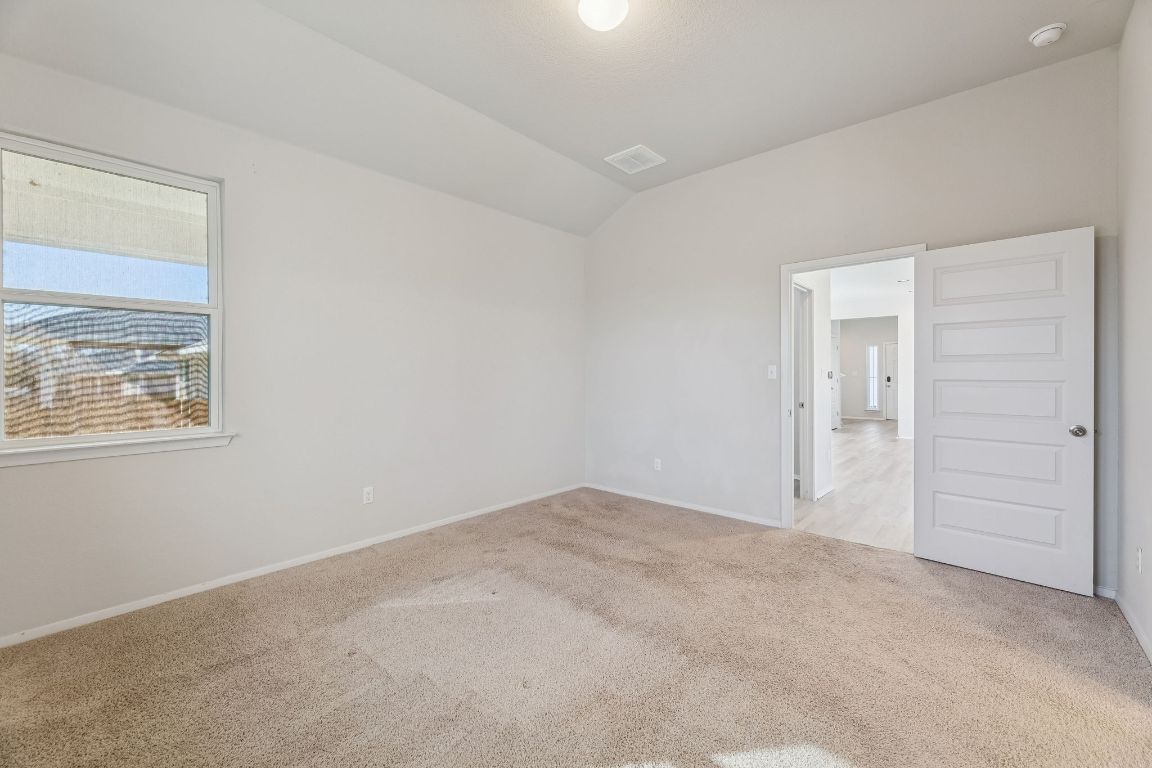 316 Insider Loop Elgin, TX 78621 - Photo 11 of 39 Empty room with light carpet and lofted ceiling