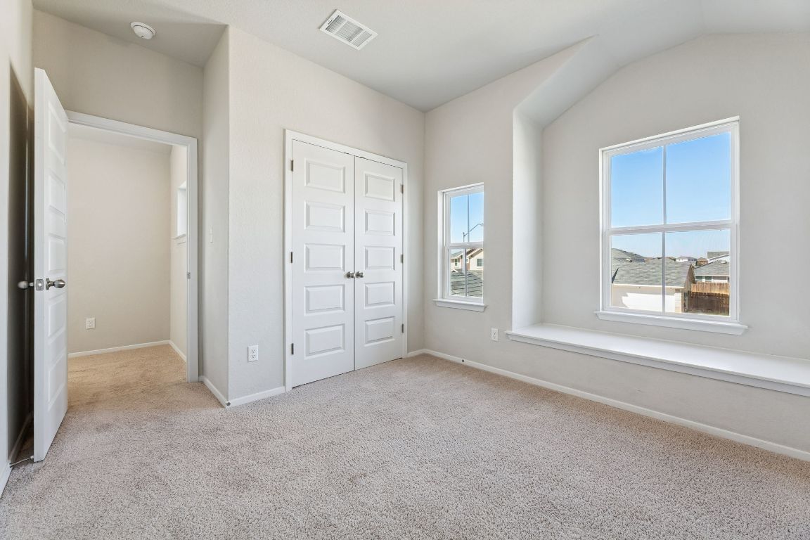 316 Insider Loop Elgin, TX 78621 - Photo 21 of 39 Unfurnished bedroom featuring light colored carpet, a closet, and vaulted ceiling