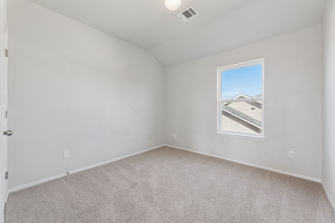 316 Insider Loop Elgin, TX 78621 - Photo 22 of 39 Spare room featuring vaulted ceiling and light colored carpet