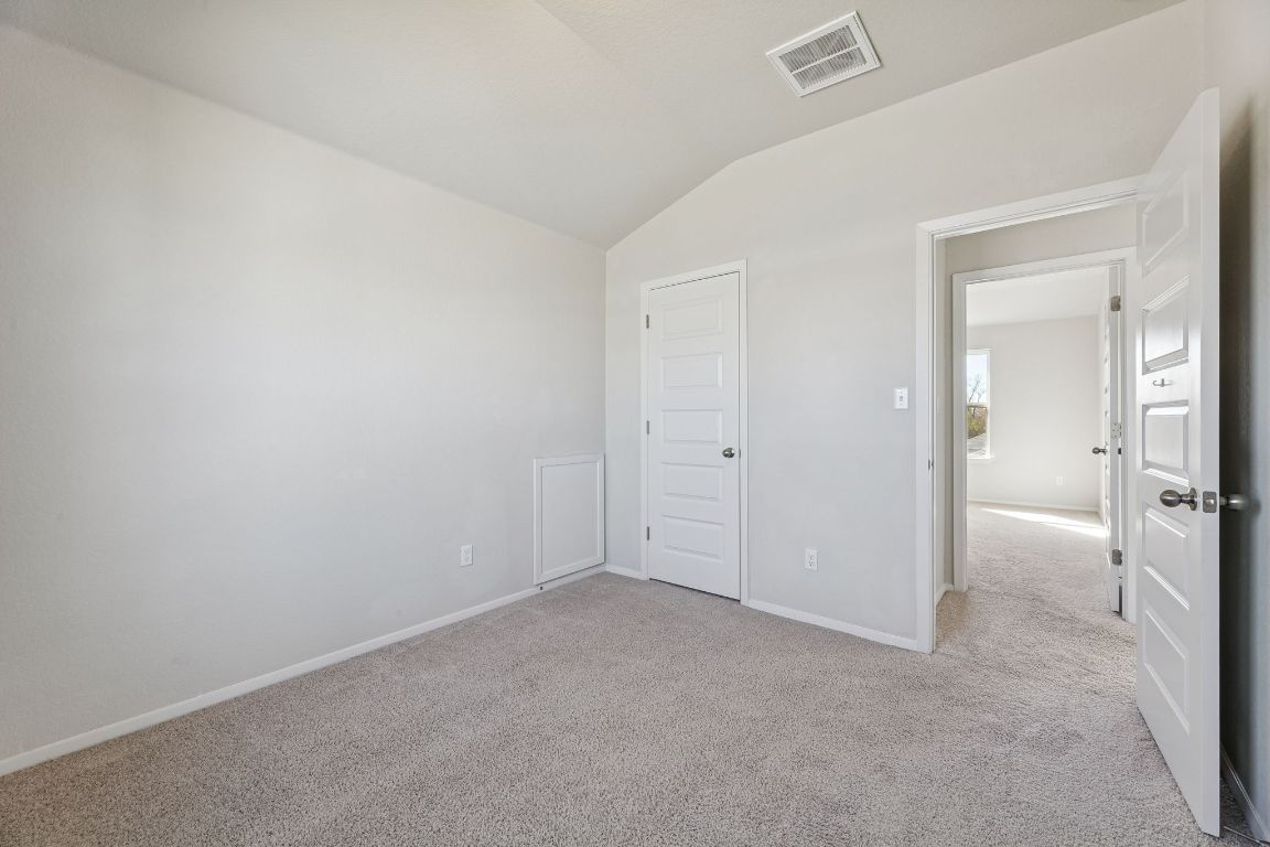 316 Insider Loop Elgin, TX 78621 - Photo 23 of 39 Unfurnished bedroom featuring lofted ceiling and light colored carpet