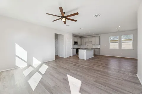a view of a livingroom with a ceiling fan and wooden floor
