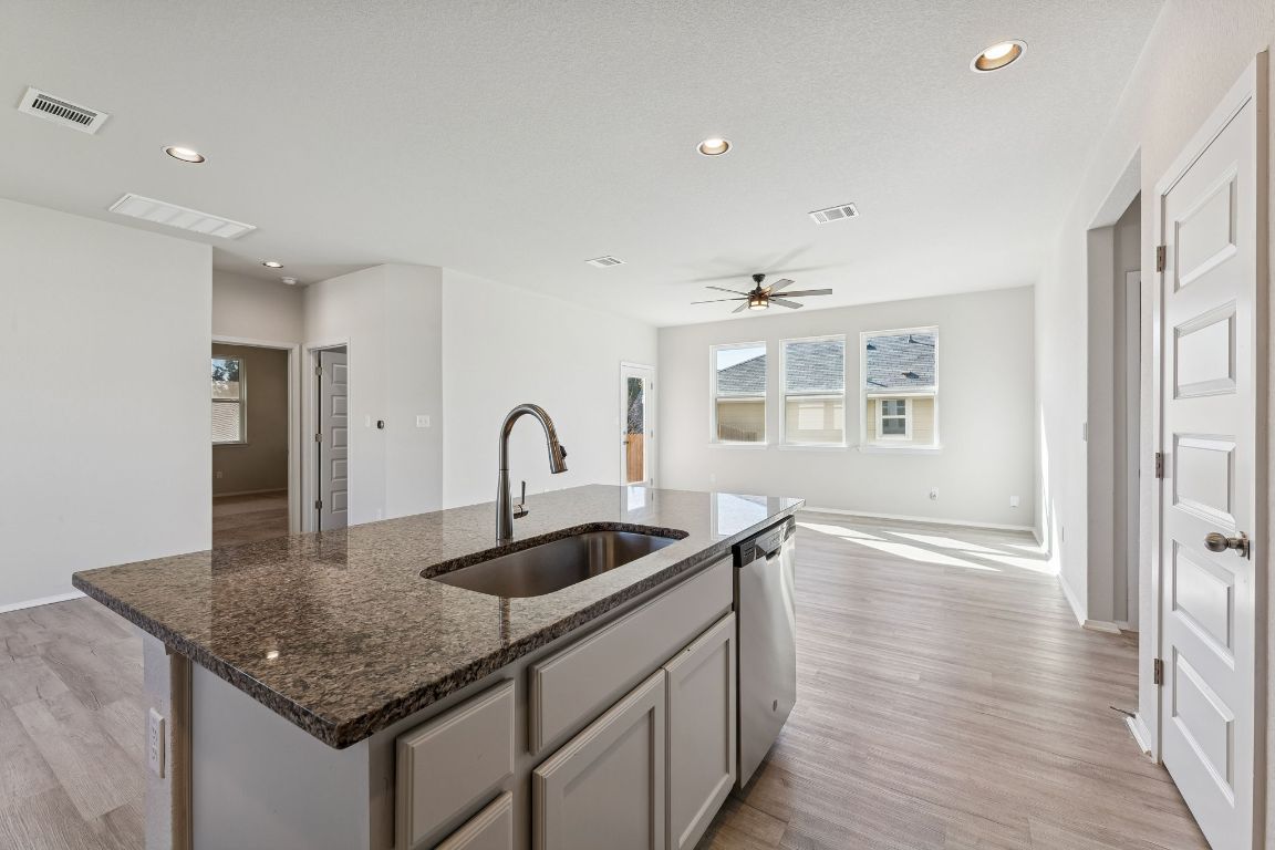 316 Insider Loop Elgin, TX 78621 - Photo 37 of 39 Kitchen with a kitchen island with sink, recessed lighting, dark stone countertops, plenty of natural light, and open floor plan