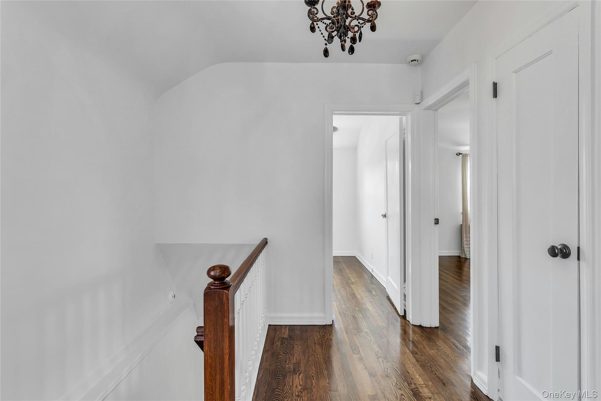 79-31 211th Street Queens, NY 11364 - Photo 12 of 28 Hall featuring an upstairs landing, dark wood finished floors, a chandelier, and baseboards