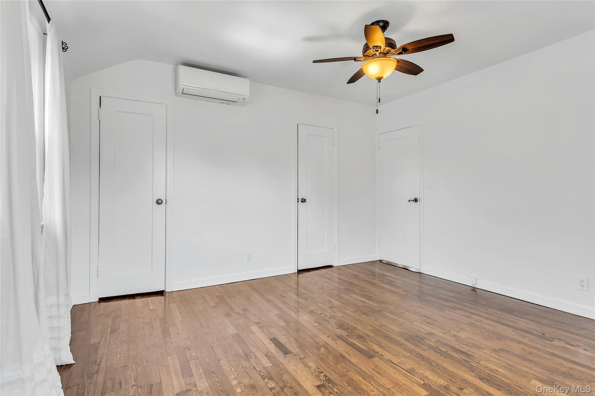 79-31 211th Street Queens, NY 11364 - Photo 17 of 28 bedroom featuring a wall mounted AC, wood finished floors, baseboards, ceiling fan