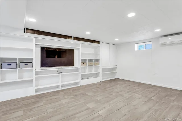 an empty room with wooden floor and fireplace