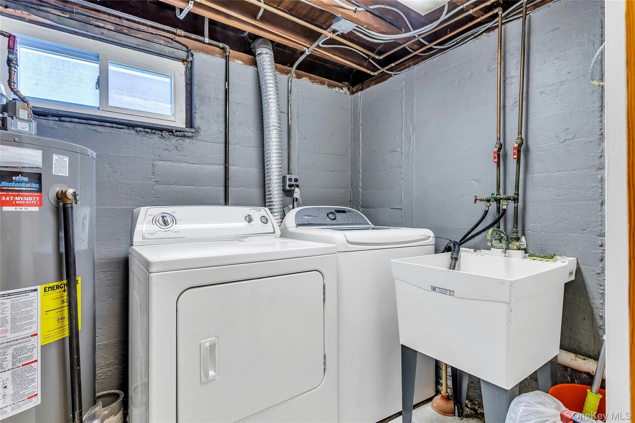 79-31 211th Street Queens, NY 11364 - Photo 24 of 28 Laundry room featuring water heater and washer and dryer