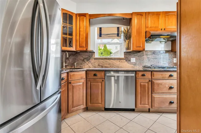 a kitchen with stainless steel appliances granite countertop a refrigerator and a stove