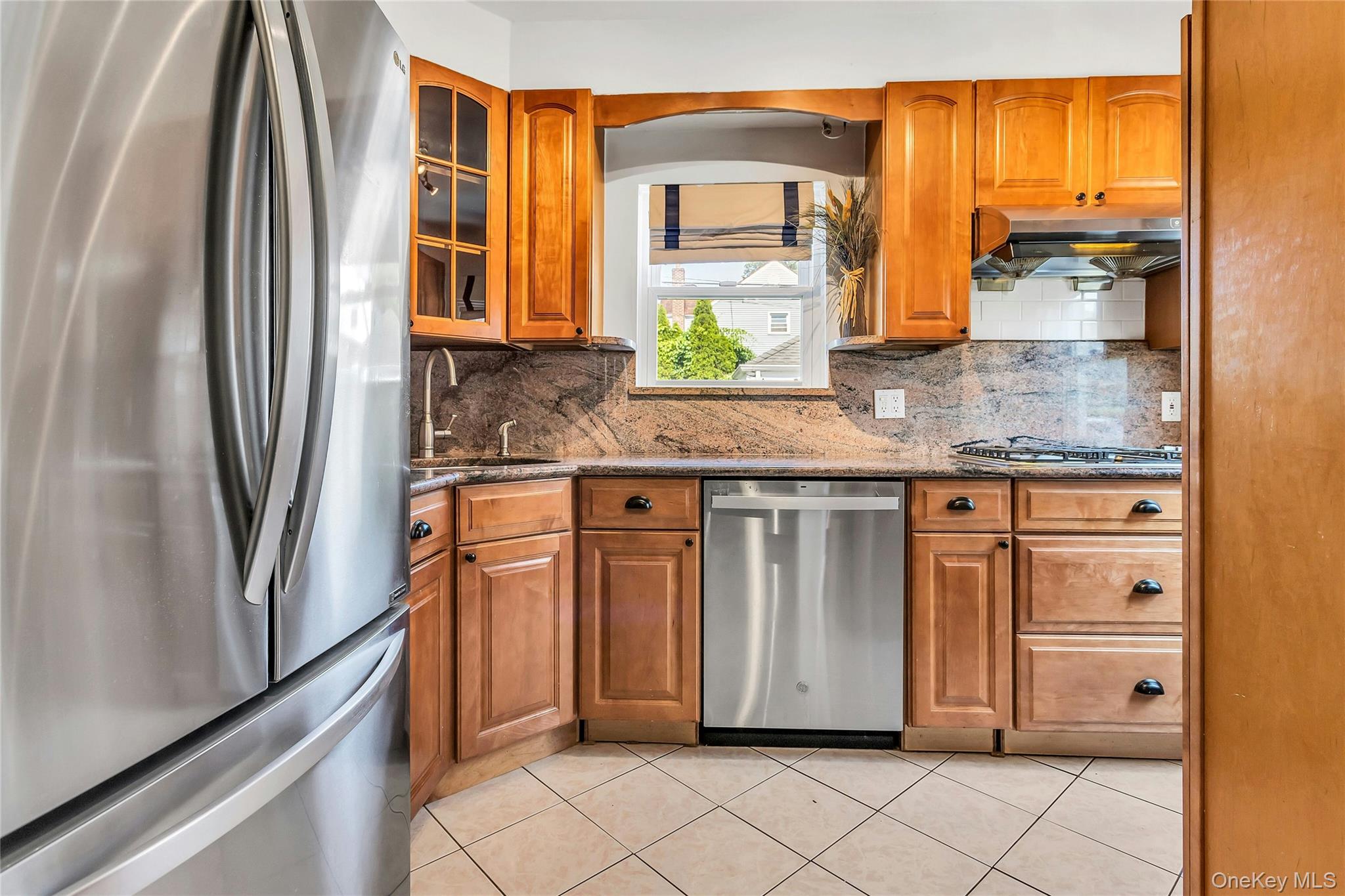79-31 211th Street Queens, NY 11364 - Photo 8 of 28 Kitchen featuring appliances with stainless steel finishes, under cabinet range hood, a sink, and cabinetry