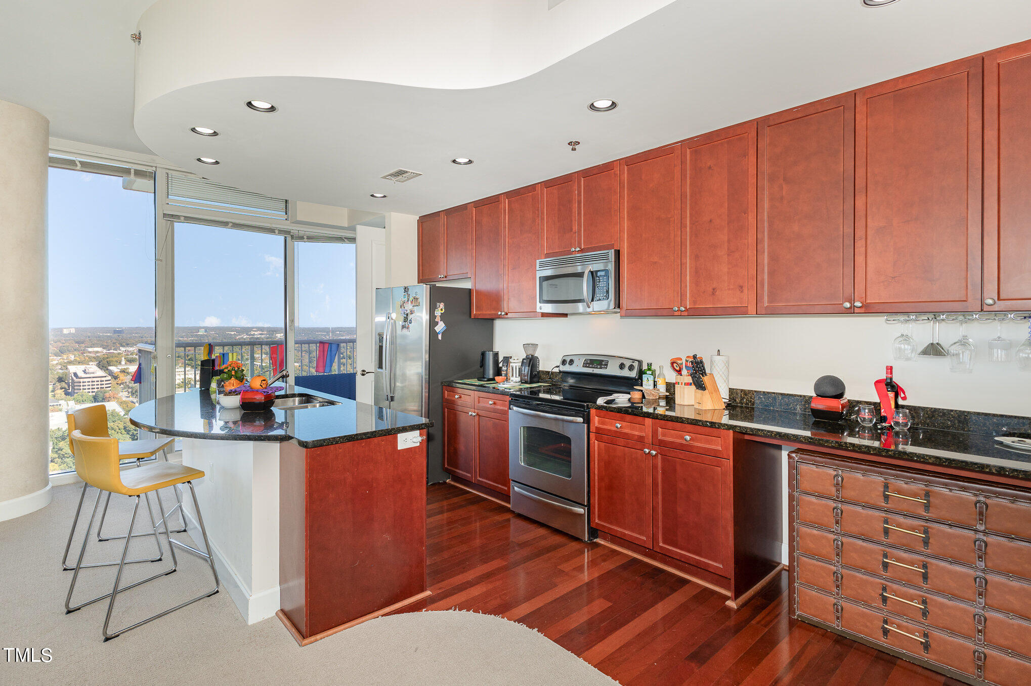 301 Fayetteville Street, Unit 2701 Raleigh, NC 27601 - Photo 5 of 26 a kitchen with stainless steel appliances a stove top oven a sink dishwasher and cabinets with wooden floor