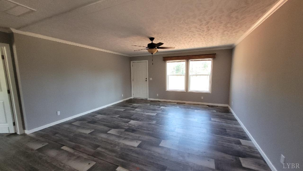 414 Loman Road Meherrin, VA 23954 - Photo 13 of 16 an empty room with wooden floor chandelier fan and windows