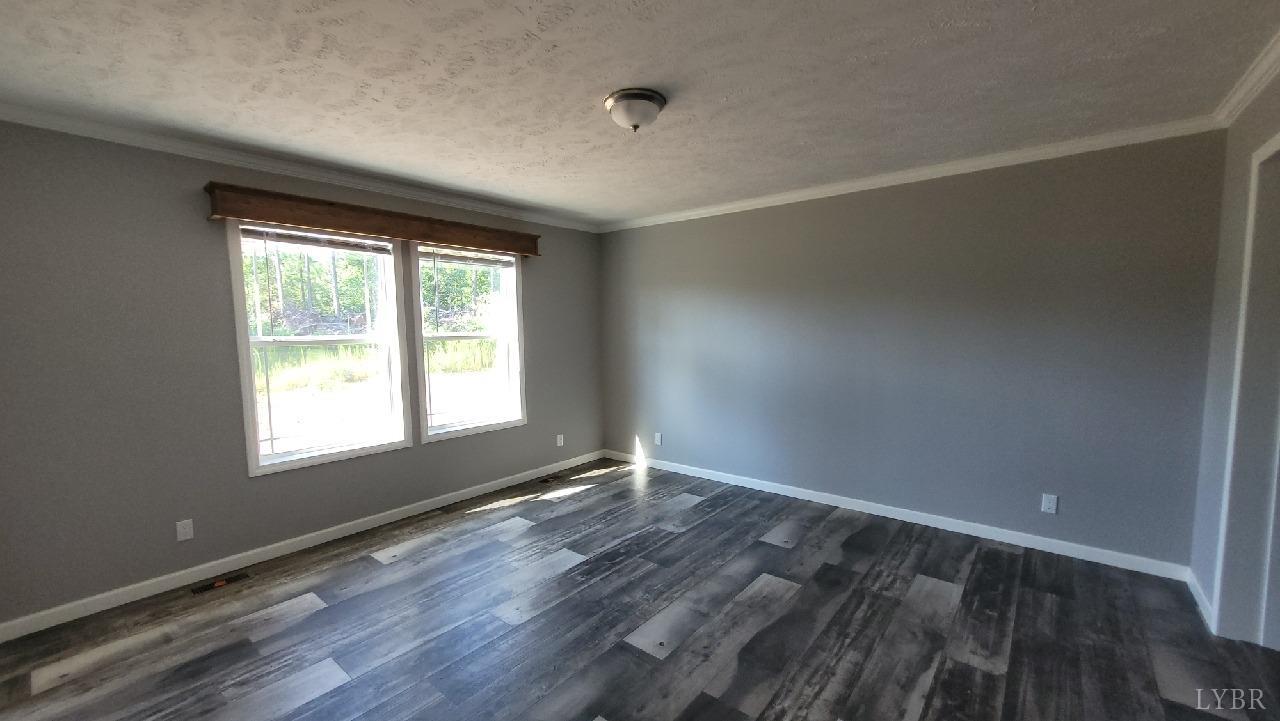 414 Loman Road Meherrin, VA 23954 - Photo 14 of 16 an empty room with wooden floor and windows