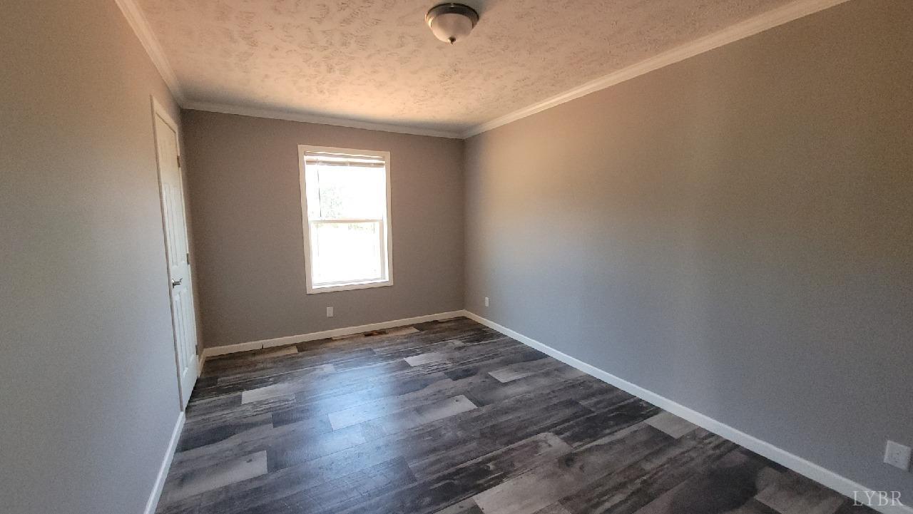 414 Loman Road Meherrin, VA 23954 - Photo 5 of 16 a view of an empty room with wooden floor and a window