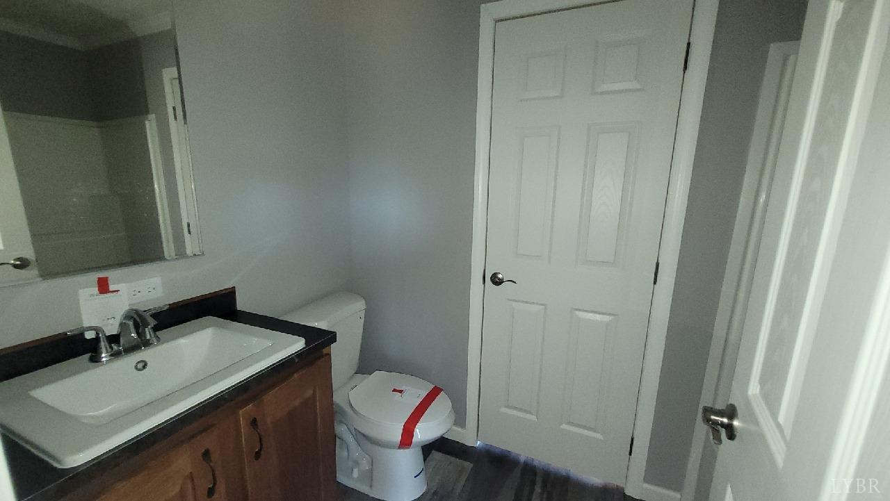 414 Loman Road Meherrin, VA 23954 - Photo 9 of 16 a bathroom with a granite countertop sink toilet and a mirror