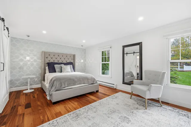 a bedroom with a bed and large window
