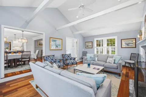 a living room with furniture and a table with wooden floor