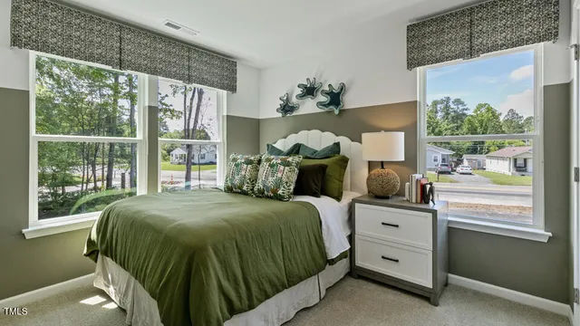 a bed sitting in a bedroom next to a window