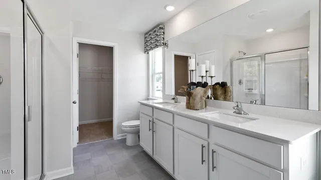 a bathroom with a double vanity sink mirror and toilet