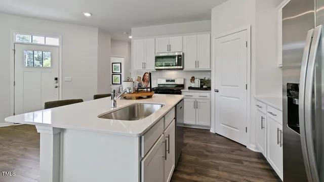 a kitchen with white cabinets and stainless steel appliances