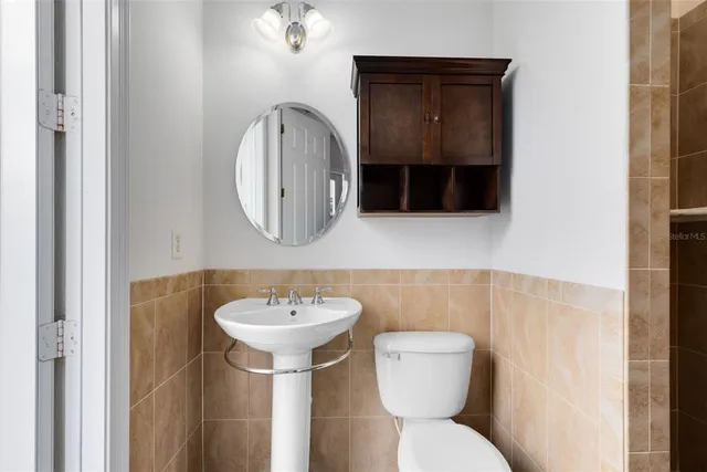 a bathroom with a toilet sink and mirror