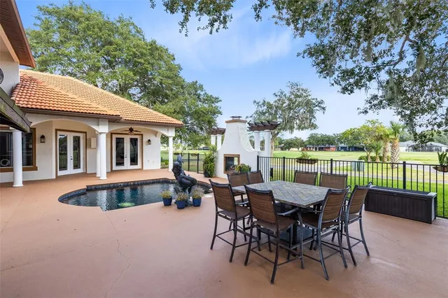 a view of a patio with table and chairs and floor to ceiling window