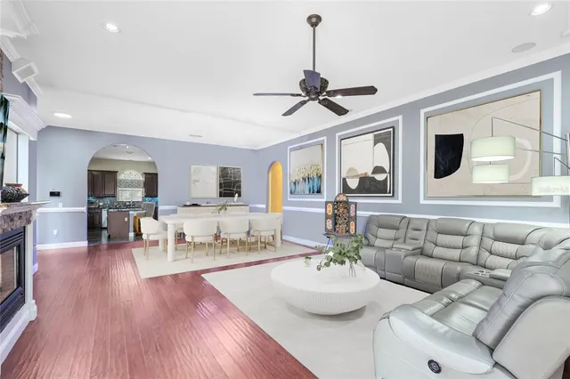 a living room with furniture kitchen view and a wooden floor