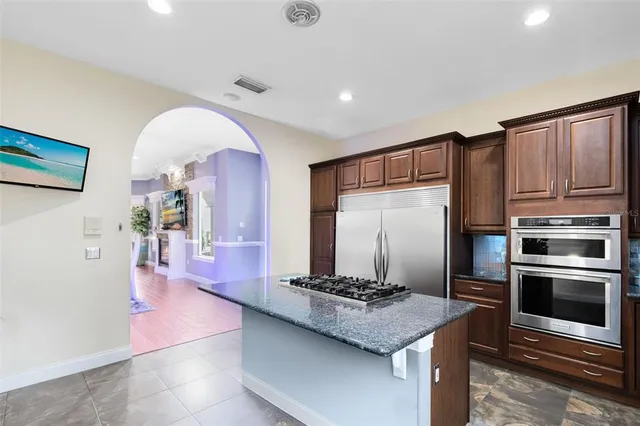 a kitchen with stainless steel appliances granite countertop a stove a sink and a refrigerator