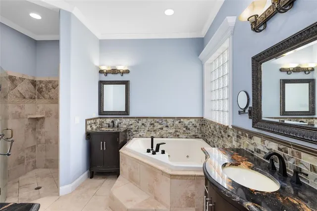 a bathroom with a granite countertop tub sink and mirror