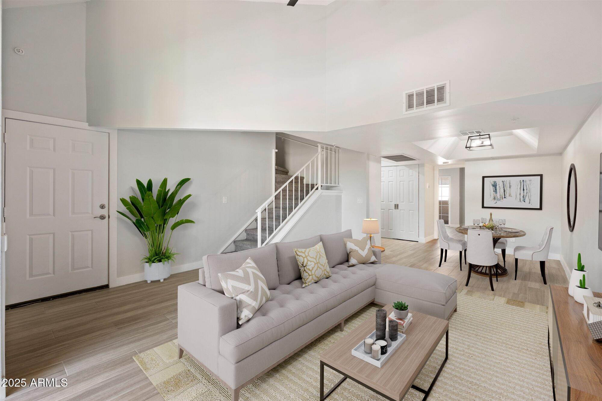 a living room with furniture potted plant and a wooden floor