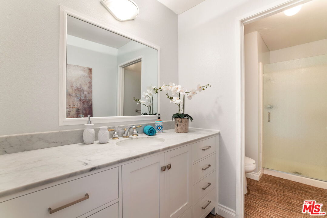 2829 Bottlebrush Drive Los Angeles, CA 90077 - Photo 24 of 40 a bathroom with a granite countertop sink and a mirror