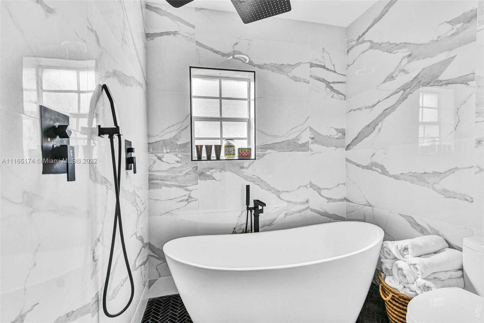 4722 Southwest 5th Street Miami, FL 33134 - Photo 16 of 36 a white bath tub sitting next to a white sink and glass door