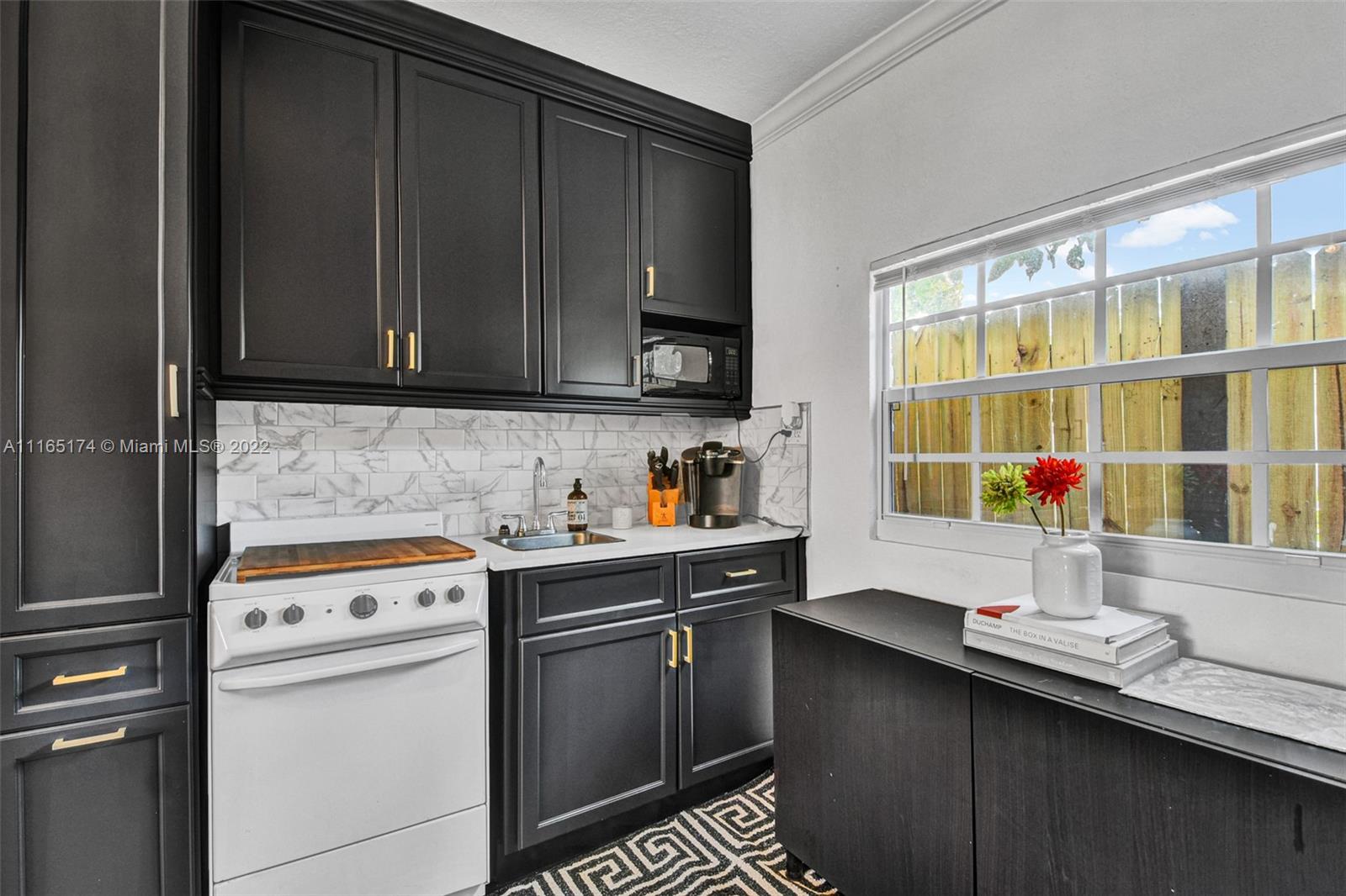 4722 Southwest 5th Street Miami, FL 33134 - Photo 30 of 36 a kitchen with stainless steel appliances a stove a sink and a microwave