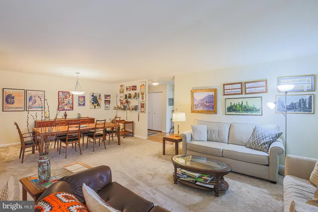 a living room with furniture and a dining table with kitchen view