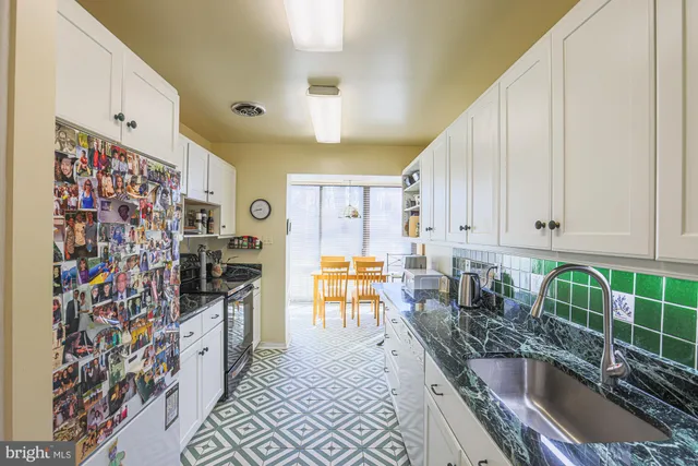 a kitchen with stainless steel appliances granite countertop a sink and a refrigerator