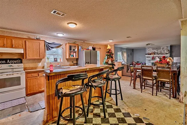 a dinning area with stainless steel appliances a sink and a refrigerator