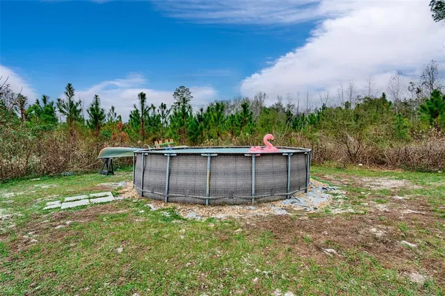 a view of a backyard with table and chairs with a yard and plants