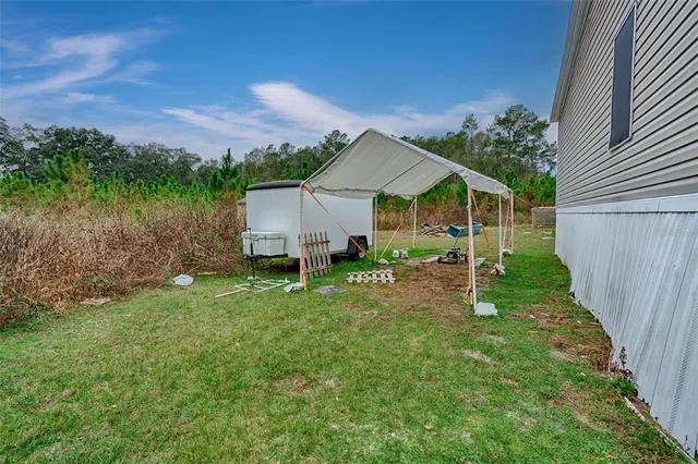 a view of a house with backyard and trees