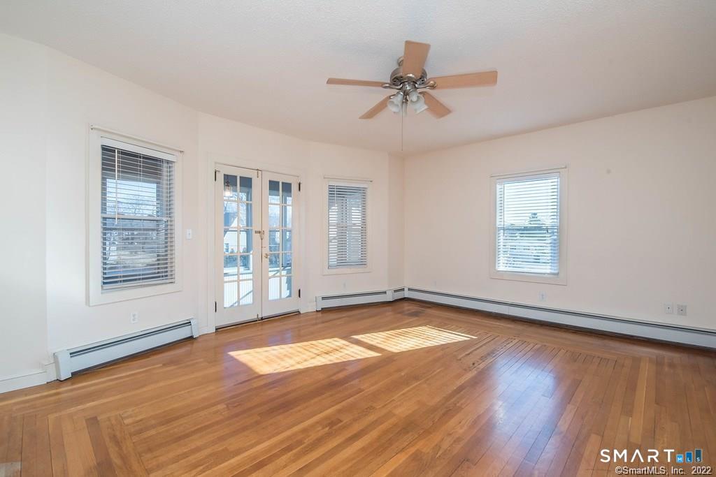 2 Pleasant Street, Unit 2 Windsor Locks, CT 06096 - Photo 2 of 11 a view of an empty room with a window and wooden floor