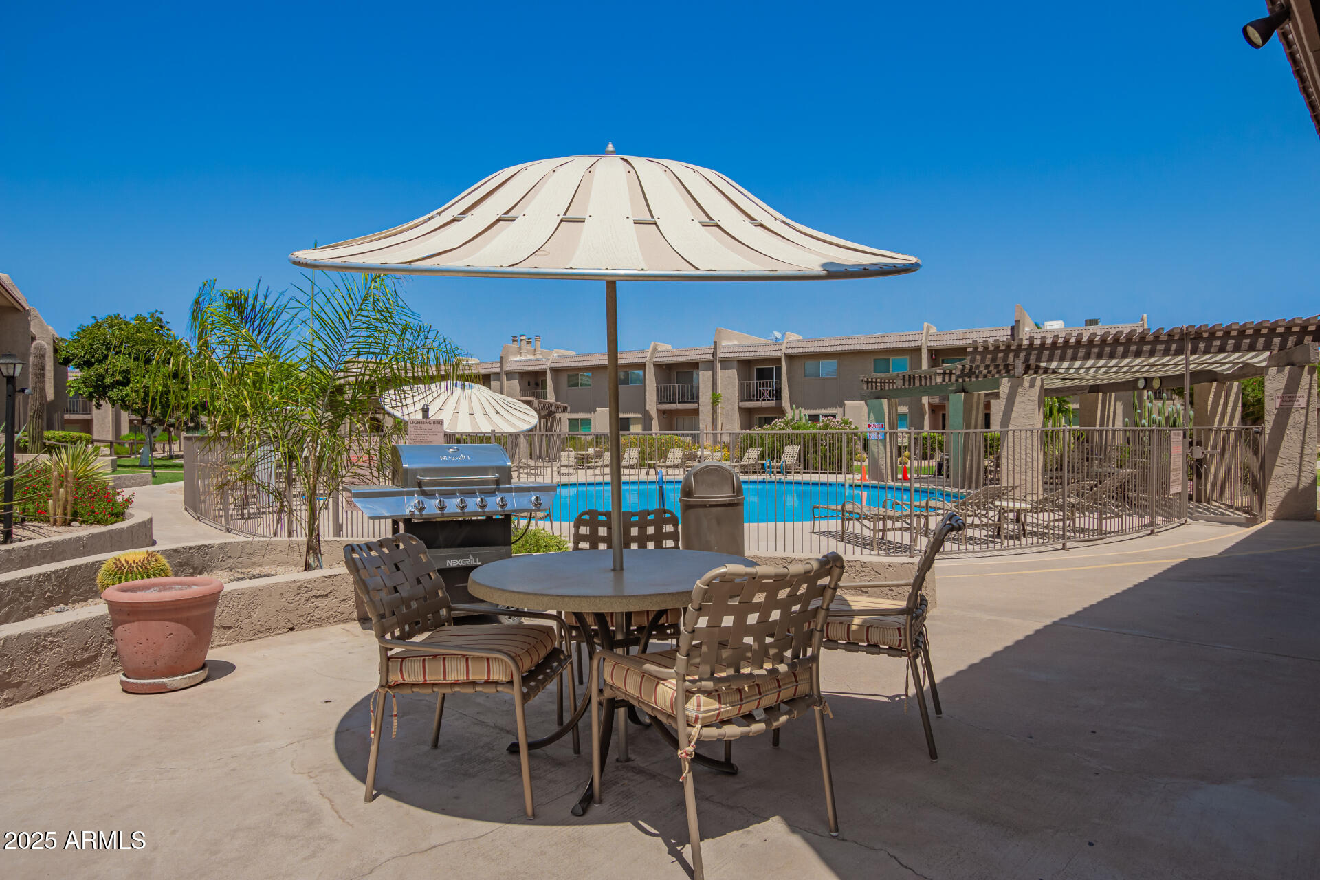 7430 East Chaparral Road, Unit 245A Scottsdale, AZ 85250 - Photo 22 of 30 a patio with a table and chairs under an umbrella