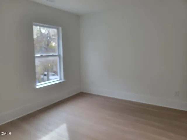 a view of a hallway with wooden floor and stairs