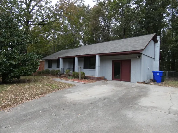 a view of a house with a yard and large tree