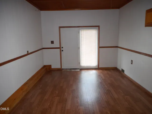 a view of a room with wooden floor and window