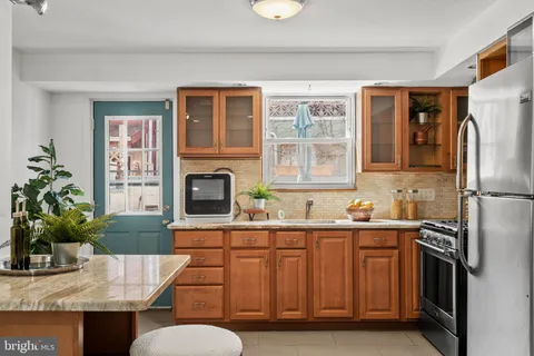 a kitchen with stainless steel appliances granite countertop a refrigerator and a stove top oven